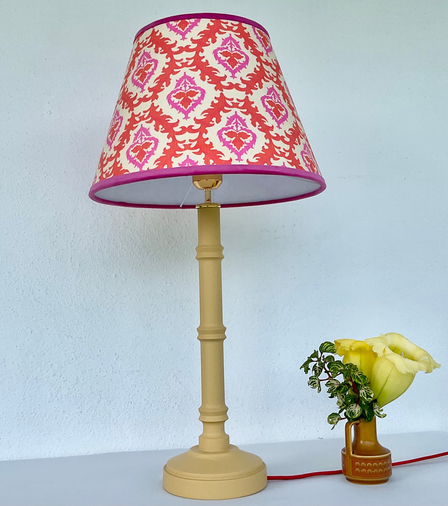 Cone shape pink and orange lampshade with yellow wooden lamp base