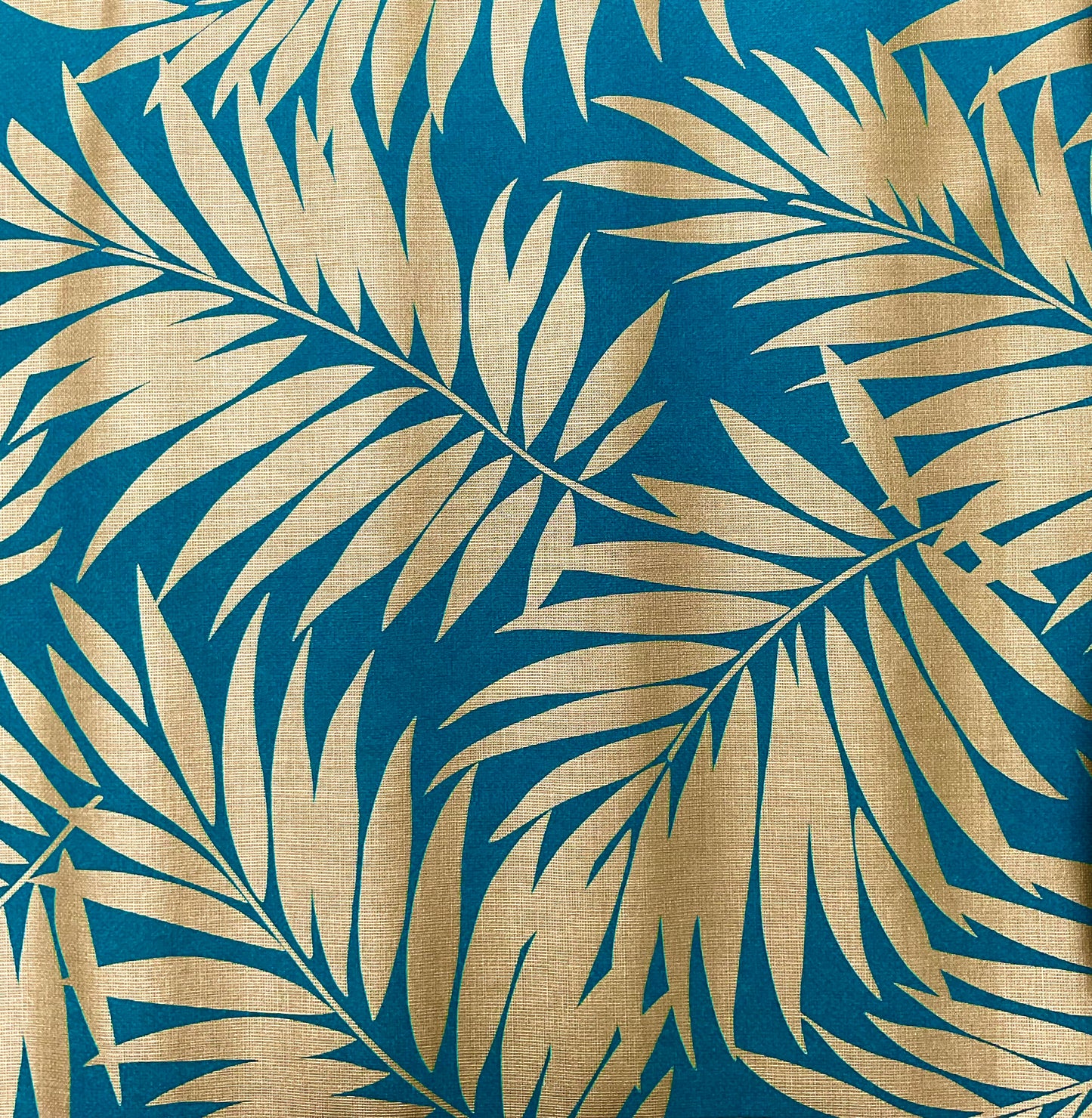 Close up of gold palm on teal background